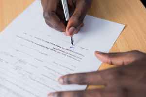 person signing paper